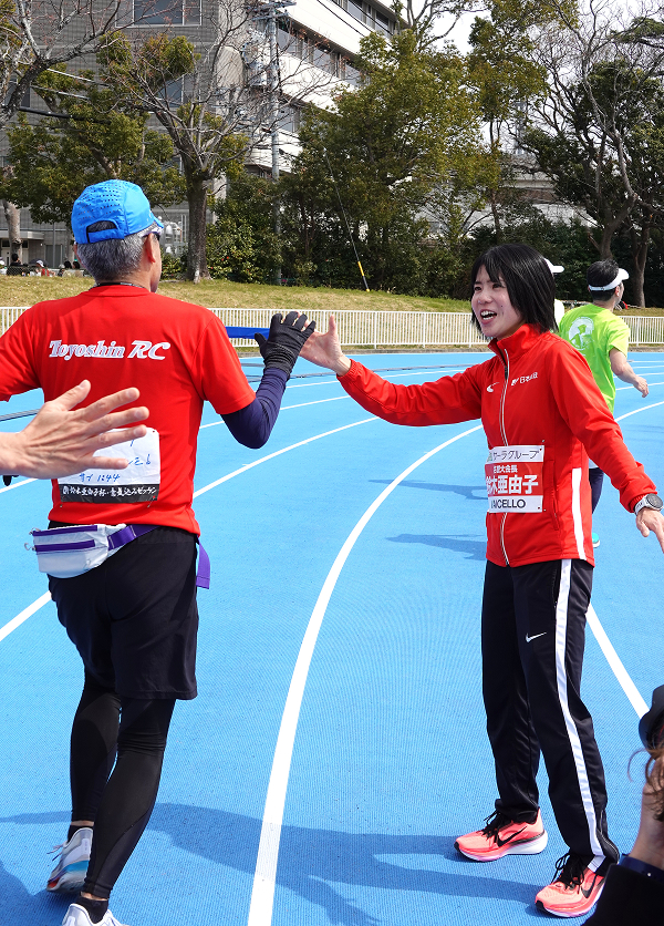 フィニッシュ付近でランナーにハイタッチをしてエールを送る様子