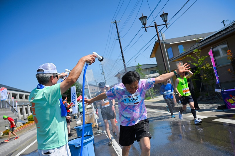 コース上では「完走シャワー応援隊」がランナーに水をかける