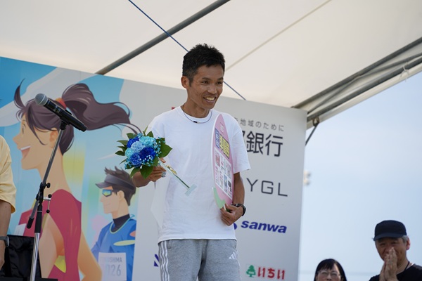 副賞（福島県産の桃、8月上旬に発送予定）を受け取るハーフ男子の部2位の森さん