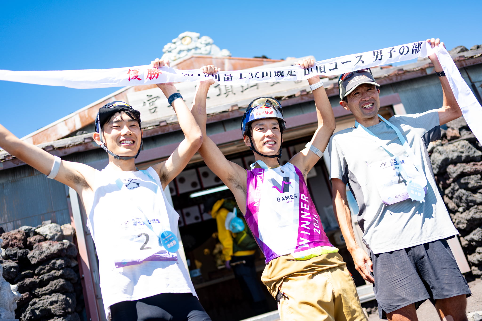 フィニッシュテープを掲げる上位3選手 （写真左から、2位山口大河選手、1位上田瑠偉選手、3位菊嶋啓選手）