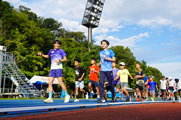トラックを走る中央大学出身の実業団ランナーや現役学生選手、参加した子どもたち